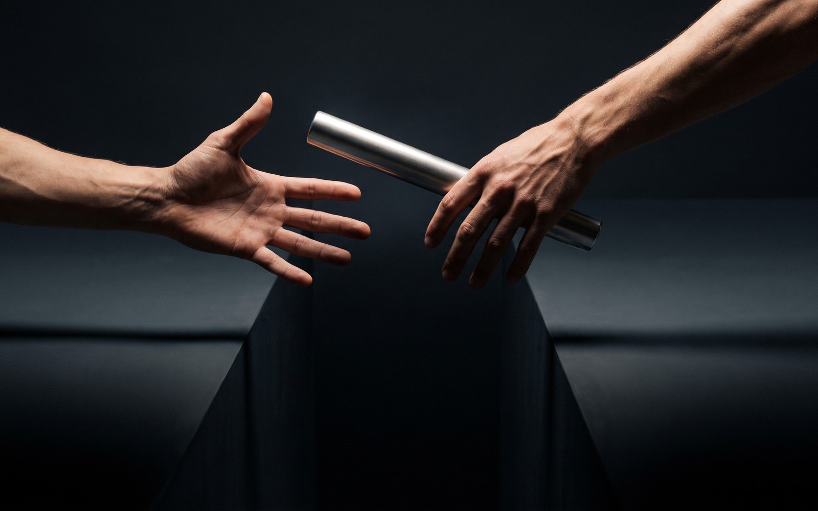 A single relay baton frozen mid-handoff between two runners over a dark chasm, one hand already open, the other not yet closed