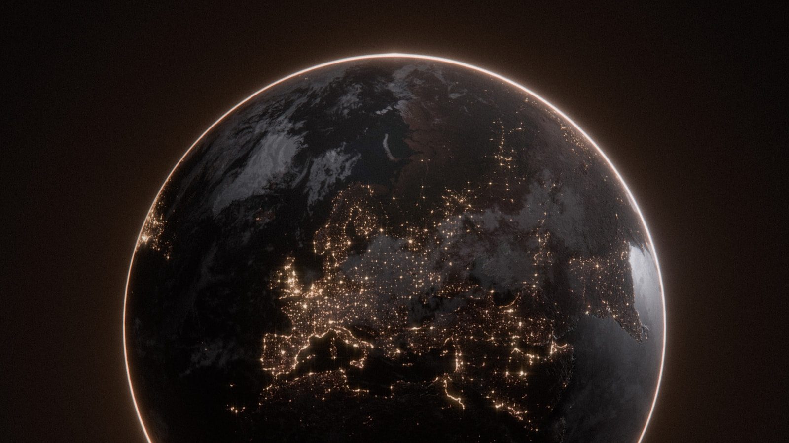 Earth seen from space at night, the glow of city lights strung along the darkened continents
