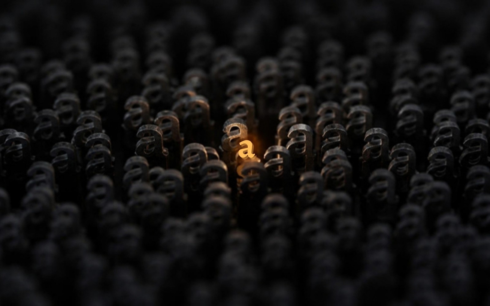 A single glowing amber letter standing out, lit and in focus, among rows of identical dark, unlit letters