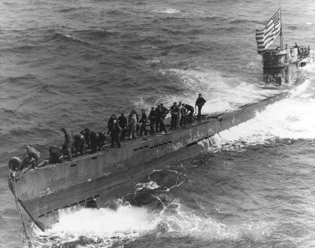 A U.S. Navy boarding party working to secure a tow line to the bow of the captured German submarine U-505, 4 June 1944.
