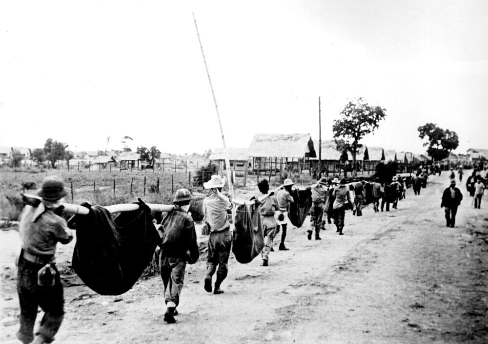 American prisoners using improvised litters to carry comrades who collapsed during the Bataan Death March, Philippines, May 1942.