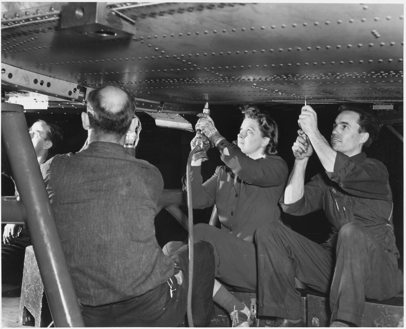 Two women workers riveting a center wing section for a B-24E Liberator bomber in the horizontal position at Ford's Willow Run plant, circa February 1943.