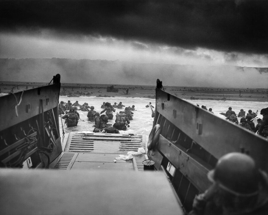 U.S. troops of the 1st Infantry Division wading ashore under fire from a landing craft at Omaha Beach, June 6, 1944.