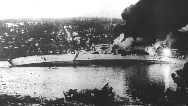 The German heavy cruiser Blücher listing heavily and sinking in the Oslofjord after being hit by fire from Oscarsborg Fortress, April 9, 1940.
