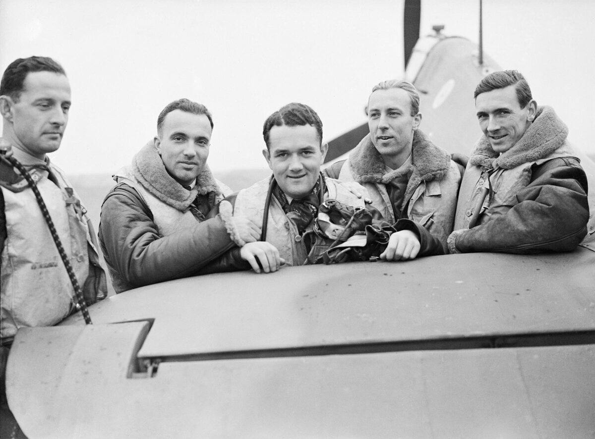 Pilots of No. 303 (Polish) Squadron RAF standing by the tail of a Hawker Hurricane at RAF Northolt, Middlesex, October 1940.
